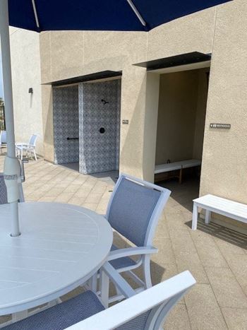 A patio with a table and chairs and an umbrella